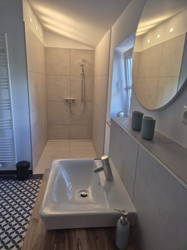 Modernes Badezimmer mit Dusche, Waschbecken und dekorativen Fliesen.